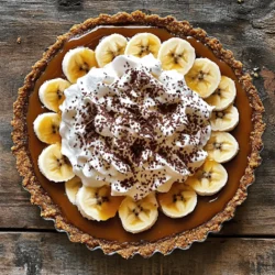 Um ein einfaches Banoffee Pie zuzubereiten, benötigst du folgende Zutaten: - 1 fertiger Kekskuchenboden (oder Graham-Cracker-Boden) - 397 g süße Kondensmilch aus der Dose - 2 große reife Bananen, in Scheiben geschnitten - 300 ml Schlagsahne - 2 Esslöffel Puderzucker - 1 Teelöffel Vanilleextrakt - Kakaopulver oder dunkle Schokoladensplitter (zur Dekoration) Die Wahl der Zutaten ist entscheidend für den Geschmack. Achte darauf, dass die Bananen reif sind. Sie sollten leicht weich sein und intensiv duften. Wähle auch eine hochwertige Kondensmilch, da sie die Basis für das Karamell bildet. Frische Schlagsahne macht die Füllung luftig und cremig. Vermeide es, alte oder überreife Bananen zu verwenden. Diese können bitter schmecken. Achte auch darauf, dass der Kekskuchenboden gut in deiner Form passt. Ein fester Boden sorgt für Stabilität. Wenn du keinen Kekskuchenboden hast, kannst du auch einen Mürbeteig verwenden. Für eine glutenfreie Variante nimm glutenfreie Kekse. Falls du keine süße Kondensmilch findest, kannst du auch selbst Karamell zubereiten. Verwende dafür Zucker, Butter und etwas Sahne. Für eine leichtere Version kannst du die Schlagsahne durch griechischen Joghurt ersetzen. Dies gibt dir eine cremige Textur, mit weniger Kalorien. Das sind einige einfache Alternativen, die du ausprobieren kannst. Um das Karamell zu machen, nimm die süße Kondensmilch. Erhitze sie in einem kleinen Topf. Stelle den Herd auf mittlere bis niedrige Hitze. Rühre die Milch ständig mit einem Löffel. Nach 10 bis 15 Minuten wird die Masse dick und hat eine goldene Farbe. Alternativ kannst du die Milch in die Mikrowelle geben. Erhitze sie in 30-Sekunden-Intervallen und rühre dazwischen. Es dauert etwa 2 bis 3 Minuten. Das Karamell ist jetzt bereit. Nimm deinen fertigen Kekskuchenboden. Gieße das dicke Karamell gleichmäßig darauf. Nutze einen Spatel, um das Karamell zu verteilen. Achte darauf, dass es überall gleichmäßig ist. So bekommt jeder Bissen diesen köstlichen Karamellgeschmack. Jetzt kommen die Bananen. Schneide zwei große, reife Bananen in dünne Scheiben. Lege sie schön über das Karamell. Du kannst ein Muster machen, das dir gefällt. Danach bereitest du die Sahne vor. In einer Schüssel kombinierst du die Schlagsahne, Puderzucker und Vanilleextrakt. Schlage die Mischung mit einem Mixer, bis weiche Spitzen entstehen. Achte darauf, die Sahne nicht zu lange zu schlagen. Verteile die Sahne dann über die Bananen. Glätte die Oberfläche mit dem Spatel. Zuletzt kannst du die Oberfläche mit Kakaopulver oder Schokoladensplittern dekorieren. Jetzt ist deine Banoffee Pie fast fertig. Stelle sie für mindestens 1 Stunde in den Kühlschrank. So wird sie fest und lecker. Ein häufiger Fehler ist das Übermixen der Sahne. Das kann die Sahne zu fest machen. Achte darauf, dass du nur bis zu weichen Spitzen schlägst. Ein anderer Fehler ist, die Bananen zu früh hinzuzufügen. Sie können sonst braun werden. Warte bis kurz vor dem Servieren. Für eine perfekte Konsistenz des Karamells, rühre ständig. Achte darauf, dass es nicht anbrennt. Es sollte dick und cremig sein. Wenn du die Mikrowelle nutzt, rühre alle 30 Sekunden. So hast du mehr Kontrolle über die Konsistenz. Die Sahne sollte leicht und luftig sein, nicht zu fest. Um Zeit zu sparen, kannst du die Kondensmilch im Voraus zubereiten. Das Karamell kann bis zu einer Woche im Kühlschrank bleiben. Du kannst auch einen fertigen Keksboden verwenden. Das spart viel Zeit. Wenn du magst, kannst du die Bananen auch schon am Vortag schneiden. Das macht die Zubereitung schneller. Für das gesamte Rezept schaue dir die [Full Recipe] an. {{image_4}} Für eine glutenfreie Version wähle einen speziellen glutenfreien Keksboden. Es gibt viele Marken, die köstliche Alternativen anbieten. Achte darauf, die Zutatenliste zu überprüfen, um verstecktes Gluten zu vermeiden. Du kannst auch einen Boden aus gemahlenen Mandeln oder Haferflocken verwenden. Diese geben der Torte einen tollen Geschmack und eine schöne Textur. Um eine vegane Banoffee Pie zu machen, ersetze die süße Kondensmilch durch Kokosmilch oder vegane Karamellsoße. Nutze pflanzliche Sahne anstelle von Schlagsahne. Diese Alternativen sind einfach zu finden und schmecken wunderbar. Für den Boden kannst du einen Keksboden aus Datteln und Nüssen herstellen. So bleibt die Torte lecker und ganz ohne tierische Produkte. Du kannst das Banoffee Pie Rezept nach deinem Geschmack anpassen. Probiere, Erdnussbutter unter die Sahne zu mischen. Das gibt der Torte einen tollen, nussigen Geschmack. Auch Karamellsoße auf der Oberseite ist eine leckere Option. Streue geröstete Nüsse oder Schokoladensplitter darüber für extra Crunch. Experimentiere mit verschiedenen Früchten wie Himbeeren oder Erdbeeren für einen fruchtigen Kick. Die Lagerung deiner Banoffee Pie ist einfach. Du solltest sie immer im Kühlschrank aufbewahren. Das hilft, die Frische zu erhalten. Decke die Torte gut ab. Verwende Frischhaltefolie oder eine Tortenbox. So bleibt die Sahne fluffig und die Bananen frisch. Im Kühlschrank bleibt die Banoffee Pie bis zu drei Tage frisch. Nach dieser Zeit kann die Sahne wässrig werden. Auch die Bananen können braun werden. Es ist am besten, die Torte frisch zu essen, um den besten Geschmack zu genießen. Das Einfrieren von Banoffee Pie ist möglich, aber nicht ideal. Wenn du sie einfrierst, wird die Textur der Sahne leiden. Um sie einzufrieren, schneide die Torte in Stücke. Wickele jedes Stück gut ein. Lege sie in einen luftdichten Behälter. So kannst du sie bis zu einem Monat aufbewahren. Zum Auftauen lege die Torte einfach in den Kühlschrank. Warte, bis sie vollständig aufgetaut ist, bevor du sie genießt. Du kannst Banoffee Pie ohne gesüßte Kondensmilch machen, indem du eine Mischung aus Sahne und Zucker verwendest. Koche 300 ml Sahne mit 100 g Zucker, bis sie dick wird. Rühre die Mischung gründlich. Lass sie abkühlen, bevor du sie auf den Keksboden gießt. Diese Methode gibt dir eine ähnliche Süße und Konsistenz. Ja, du kannst frische Bananen im Voraus schneiden. Achte darauf, sie mit etwas Zitronensaft zu beträufeln. Zitronensaft verhindert, dass die Bananen braun werden. So bleiben sie frisch und ansprechend. Schneide sie nicht zu früh, um die beste Textur zu erhalten. Wenn du keinen Keksboden hast, probiere einen Boden aus Haferflocken oder Mandeln. Mische 200 g zerdrückte Haferflocken mit 100 g geschmolzener Butter. Drücke die Mischung fest in die Form. Alternativ kannst du auch einen Mürbeteig verwenden. Dieser gibt einen anderen Geschmack, ist aber ebenso lecker. Im Artikel haben wir die wichtigsten Schritte zur Zubereitung von Banoffee Pie behandelt. Wir haben die benötigten Zutaten aufgelistet und Tipps zur Auswahl gegeben. Zudem haben wir einfache Schritte zur Zubereitung und Anrichtung erklärt. Wir haben häufige Fehler und Zeitersparnisse besprochen. Auch Variationen, wie glutenfreie und vegane Optionen, sind wichtig. Abschließend haben wir gezeigt, wie Sie Ihren Banoffee Pie richtig lagern. Kochen soll Spaß machen. Mit diesen Ratschlägen gelingt Ihnen der perfekte Banoffee Pie!